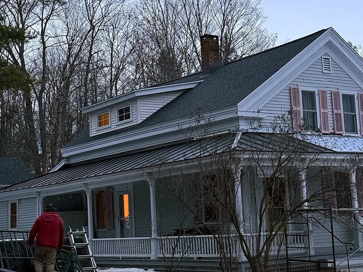 Farmhouse with a metal porch roof in winter