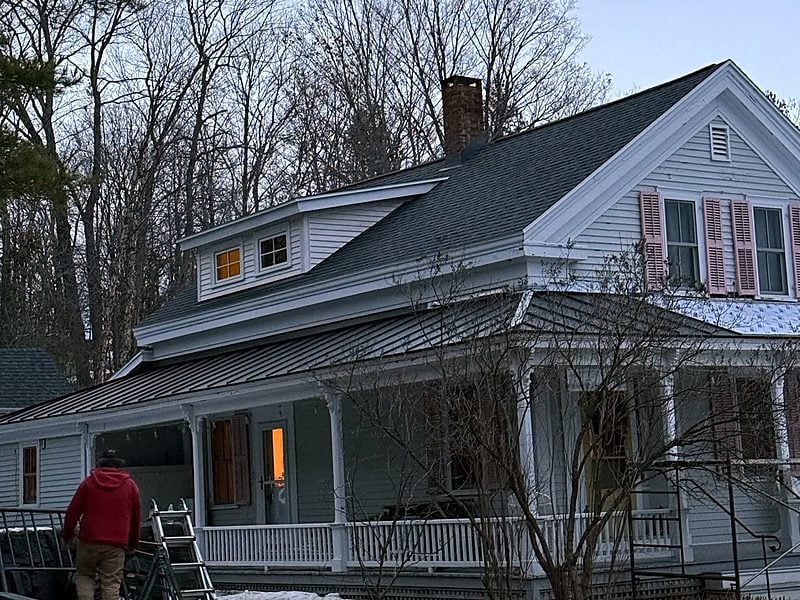 Farmhouse with a metal porch roof on a winter evening